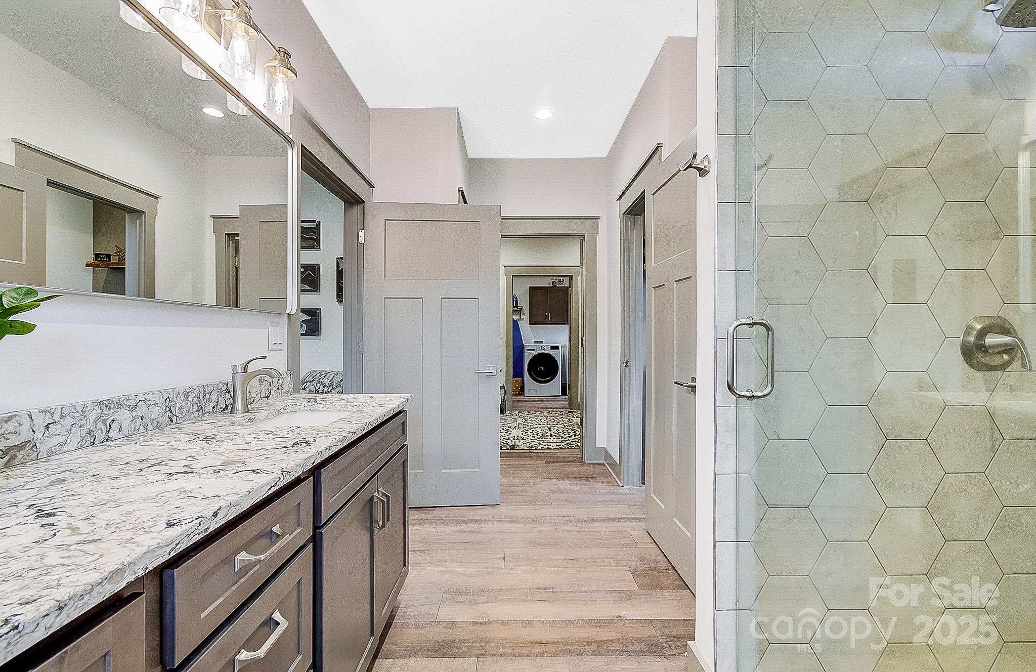250 Judson Ridge Road Arden, NC 28704 - Photo 9 of 47 a bathroom with a granite countertop sink a mirror and shower