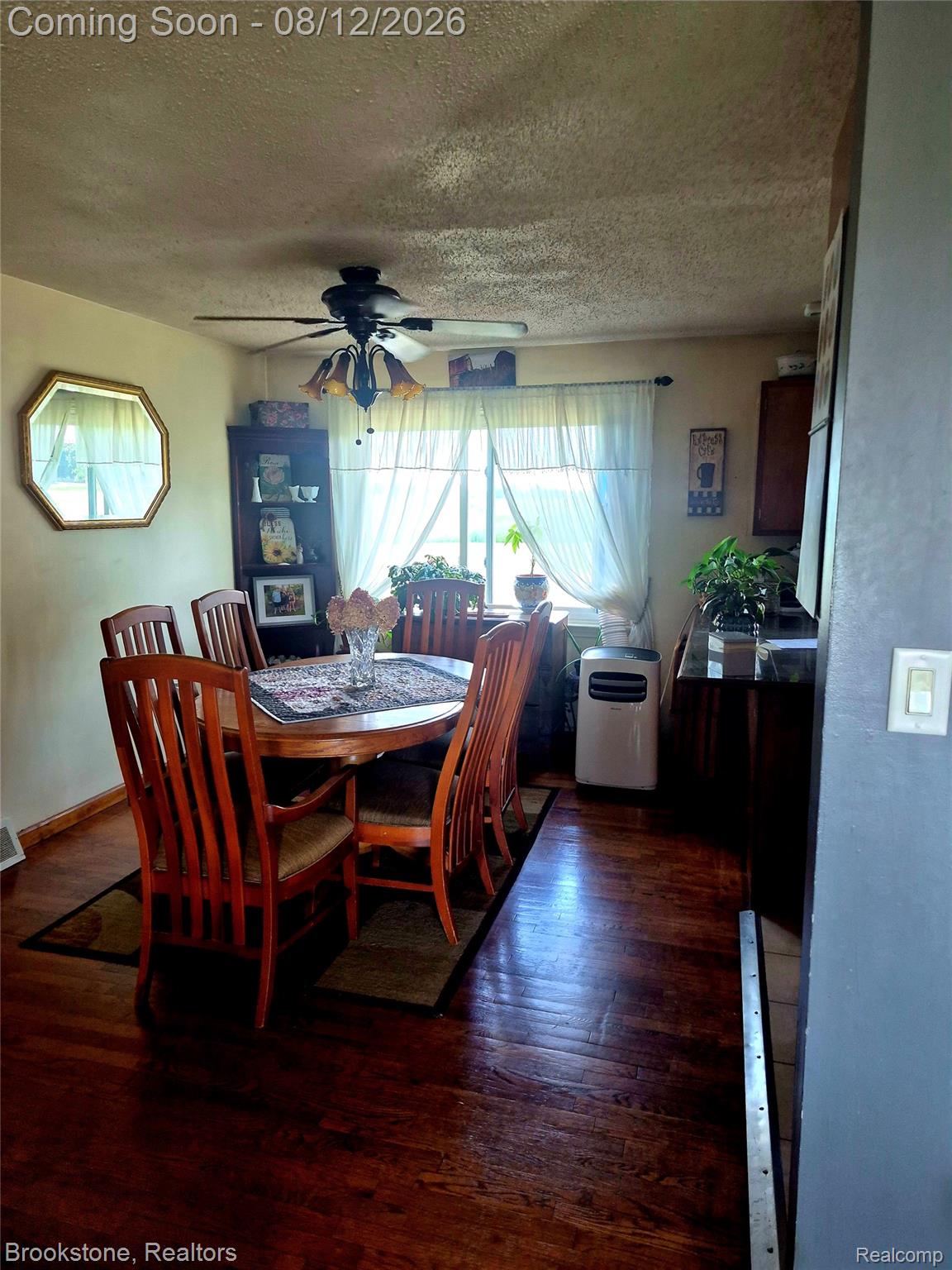 8426 Lake Pleasant Road Clifford, MI 48727 - Photo 6 of 33 Dining area featuring wood-finish flooring, a ceiling fan with integrated lighting, and natural light from a window with sheer curtains