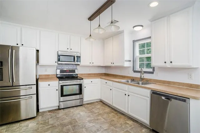 an empty room with windows and fireplace