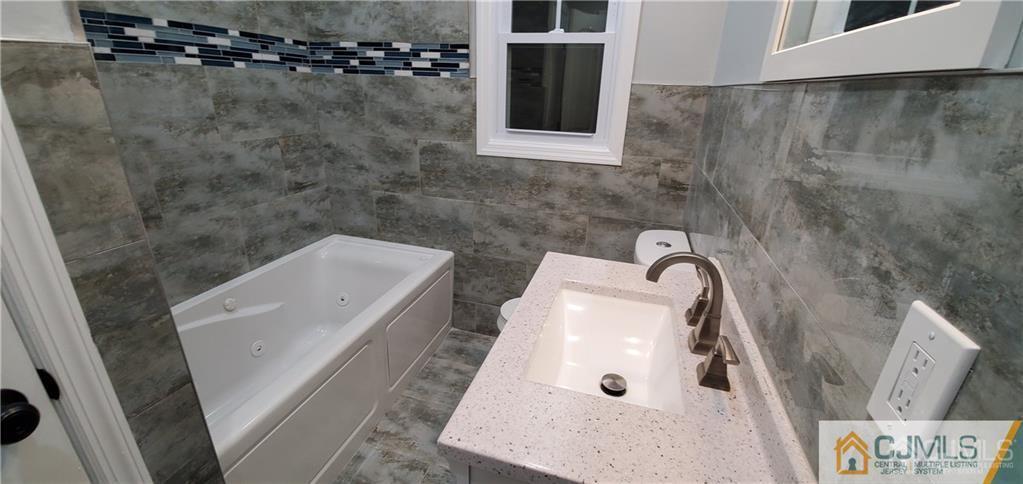 10 Huntington Road Edison, NJ 08820 - Photo 21 of 32 a bathroom with a sink a toilet and shower