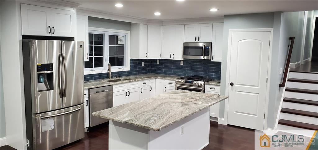 10 Huntington Road Edison, NJ 08820 - Photo 5 of 32 a kitchen with stainless steel appliances granite countertop a refrigerator a stove and a sink with wooden floors