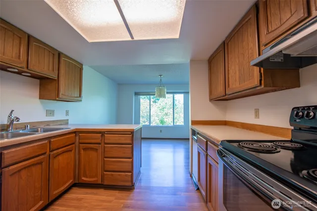 a kitchen with granite countertop wooden cabinets and a stove top oven