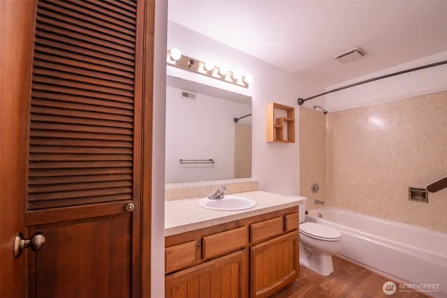 a bathroom with a double vanity sink toilet mirror and shower