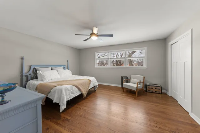 a spacious bedroom with a bed and a chair