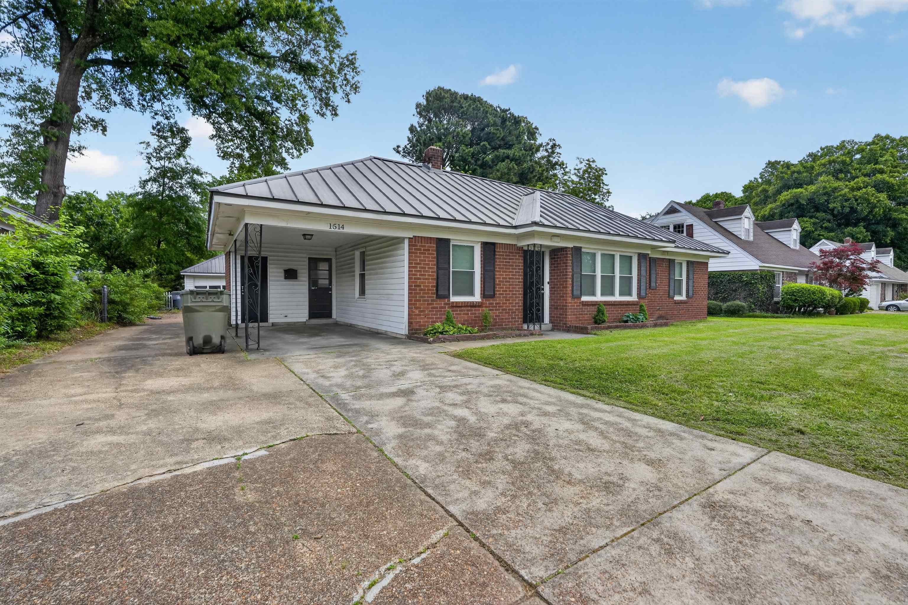 1514 Mt Moriah Road Memphis, TN 38117 - Photo 12 of 34 Brick and siding exterior featuring a metal roof and a spacious driveway