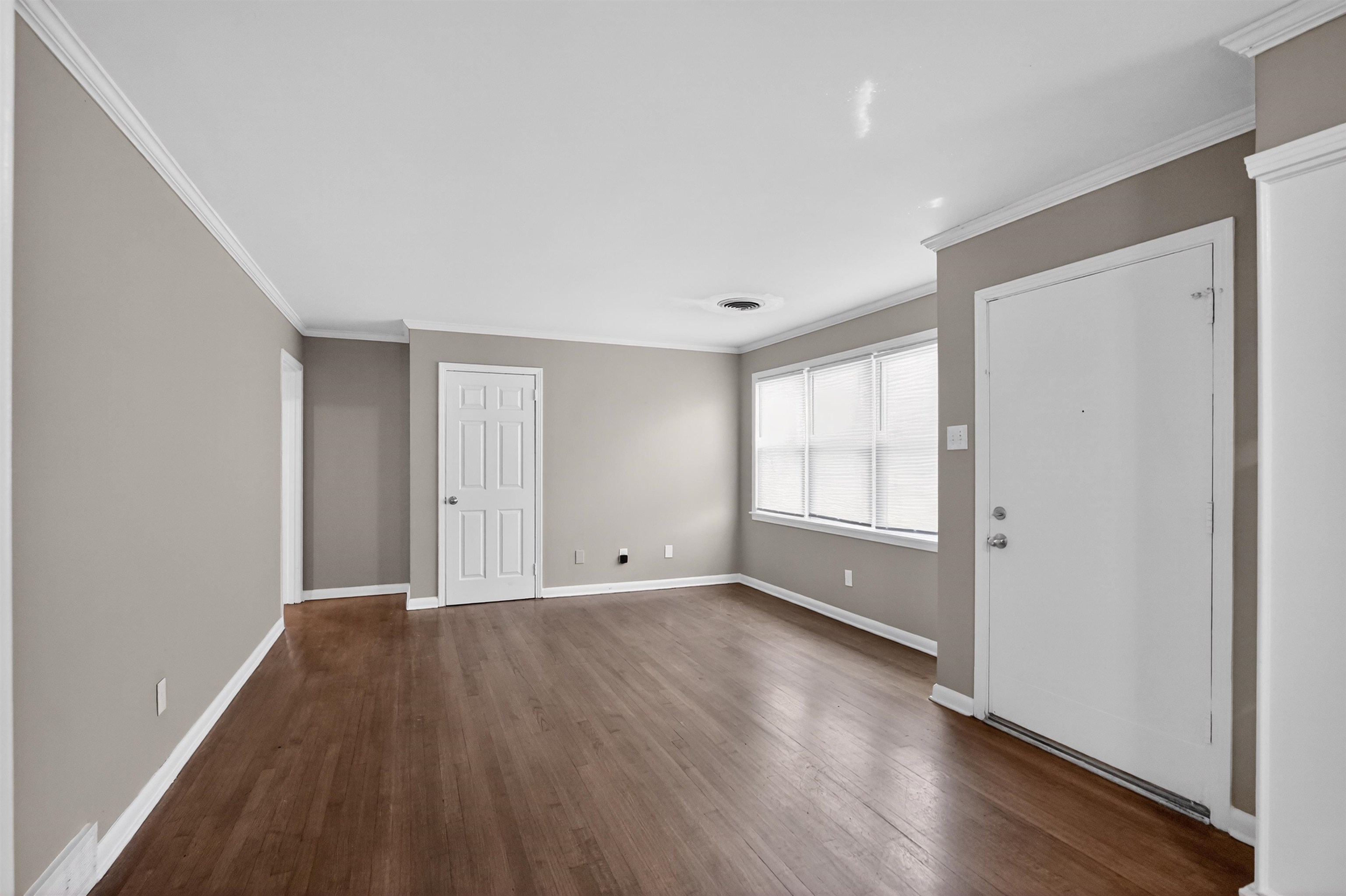 1514 Mt Moriah Road Memphis, TN 38117 - Photo 14 of 34 Spacious interior featuring wood-finish flooring, neutral-toned walls, white trim, crown molding, and multiple windows with blinds