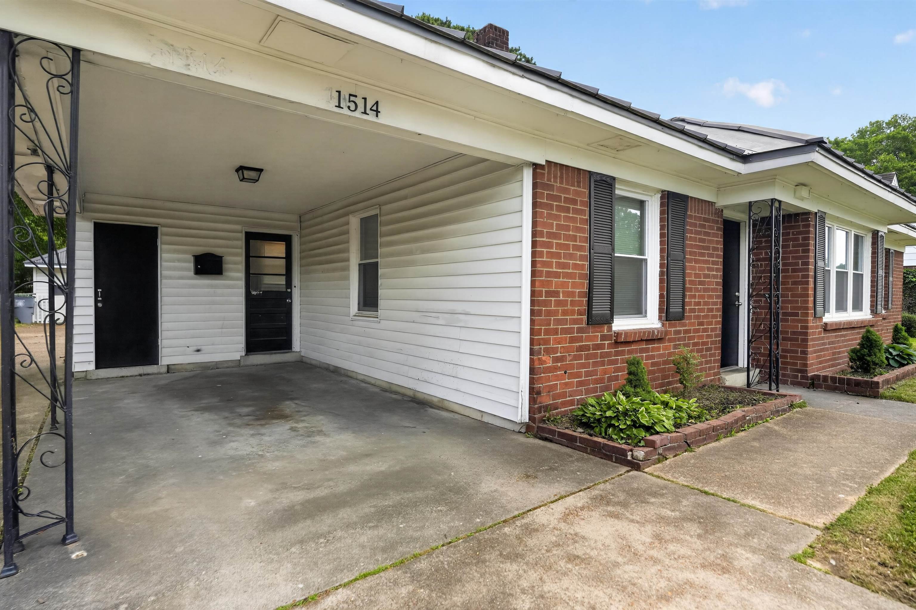 1514 Mt Moriah Road Memphis, TN 38117 - Photo 2 of 34 Brick and siding exterior featuring a covered carport with concrete flooring, a front entry door with sidelight, and an additional entry door under the carport