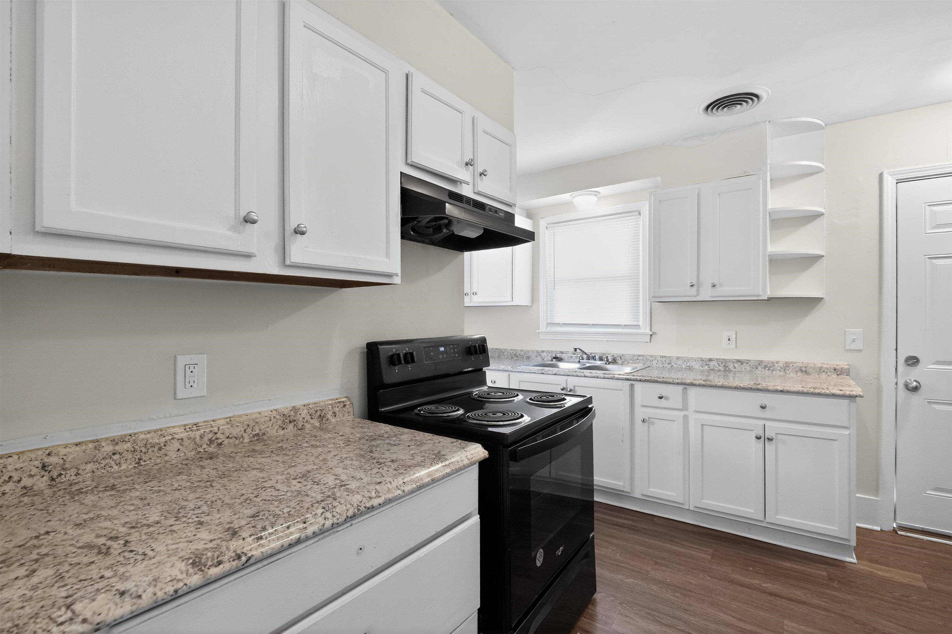 1514 Mt Moriah Road Memphis, TN 38117 - Photo 23 of 34 Kitchen featuring white cabinetry, speckled countertops, a black electric range, and wood-finish flooring