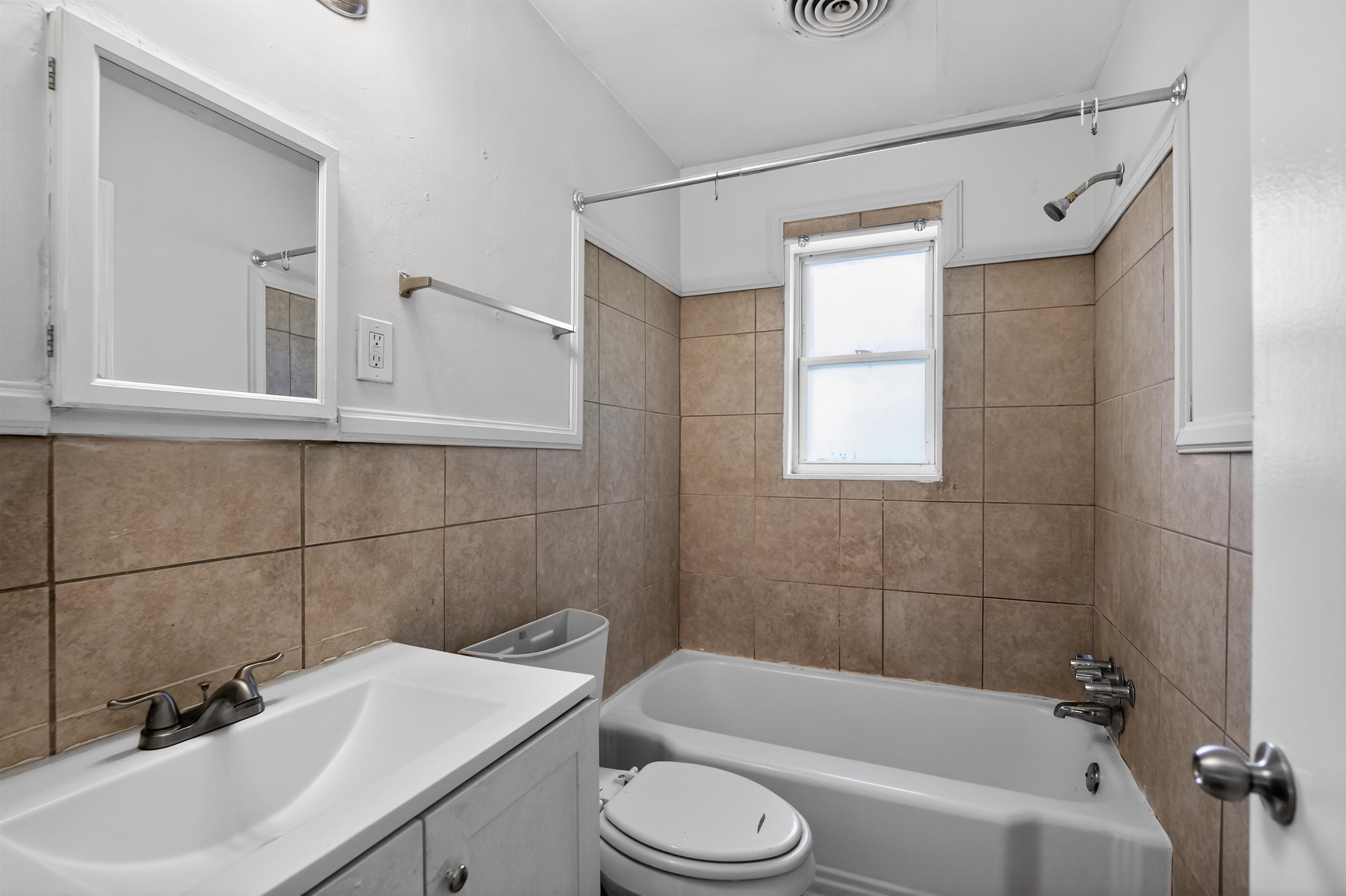 1514 Mt Moriah Road Memphis, TN 38117 - Photo 30 of 34 Bathroom featuring a white vanity with an integrated sink, a medicine cabinet, and a tiled shower/tub combination