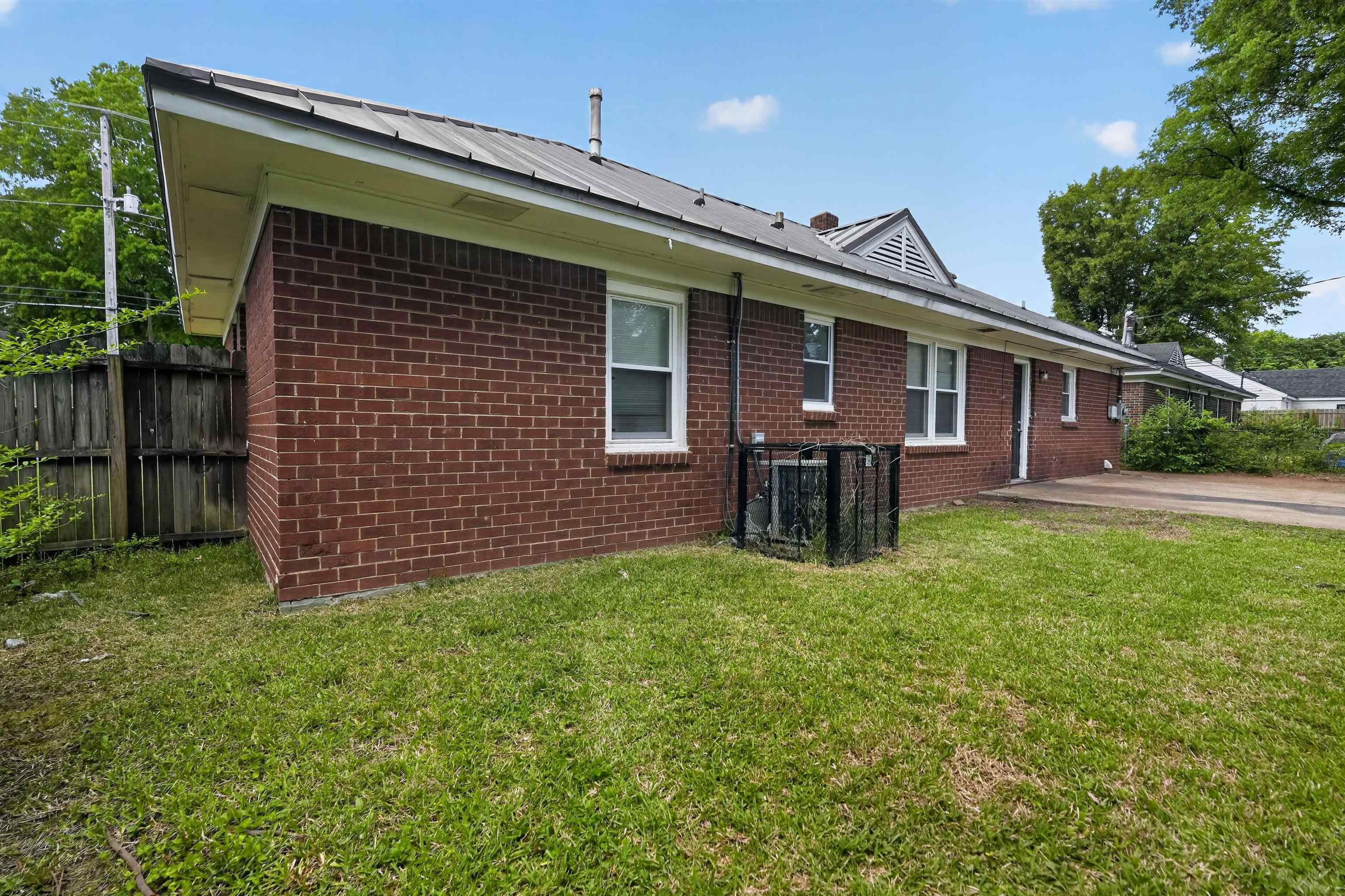 1514 Mt Moriah Road Memphis, TN 38117 - Photo 3 of 34 Brick exterior residence featuring a metal roof, white window trim, and a fenced perimeter