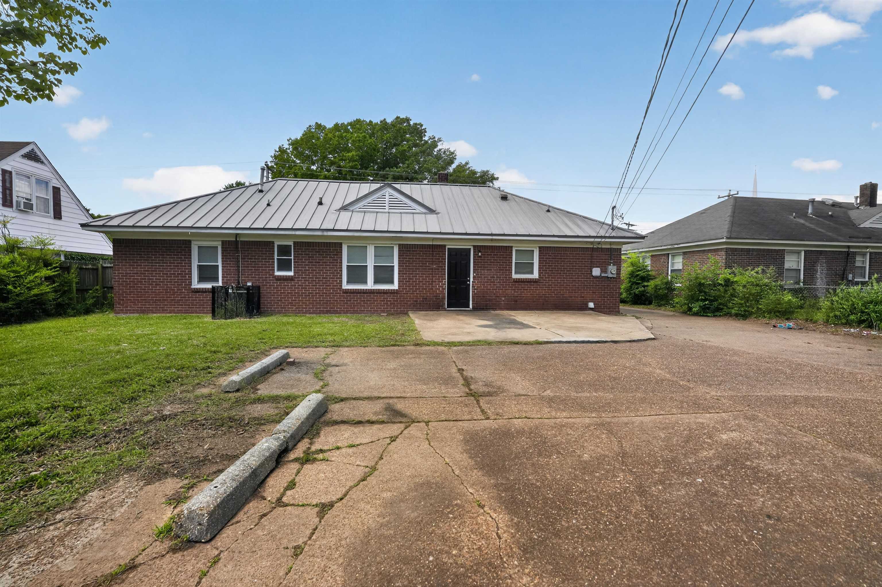 1514 Mt Moriah Road Memphis, TN 38117 - Photo 6 of 34 Brick exterior building with a metal roof, featuring multiple windows and a single entry door