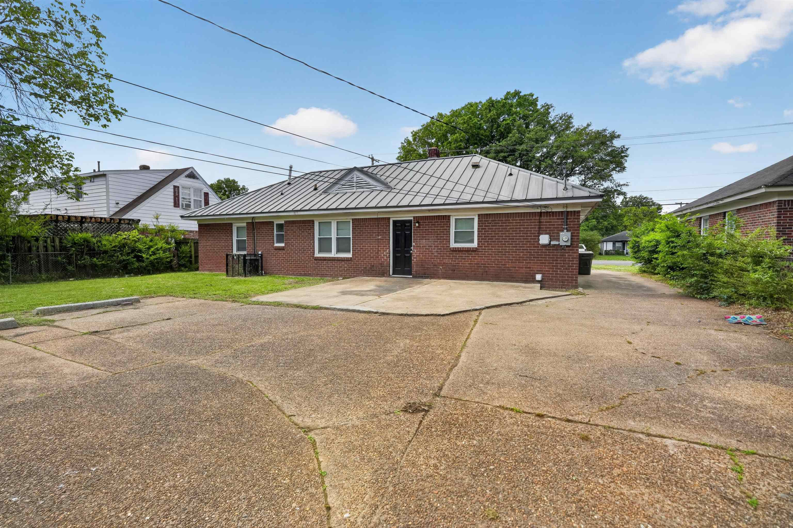 1514 Mt Moriah Road Memphis, TN 38117 - Photo 9 of 34 Brick exterior featuring a metal roof and multiple windows