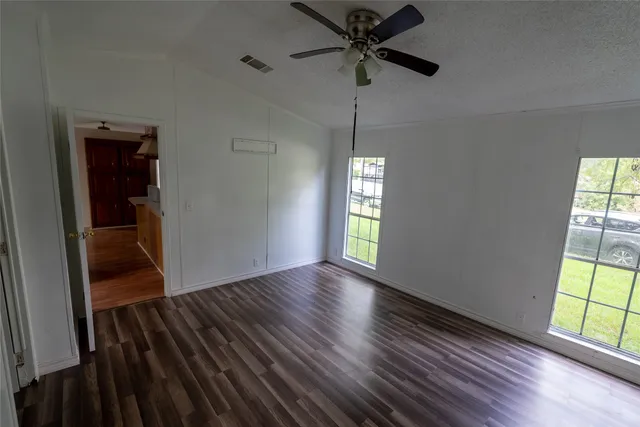 wooden floor in an empty room with a window