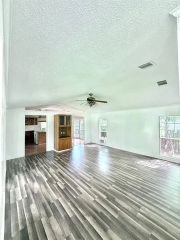 a view of a livingroom with wooden floor and a ceiling fan