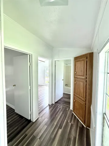 a view of a hallway with wooden floor and closet area