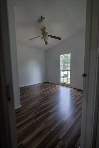 a view of room with hardwood floor and a ceiling fan