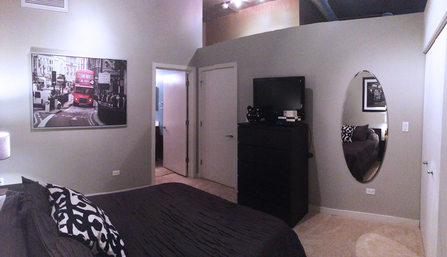 1111 West 15th Street, Unit 126 Chicago, IL 60608 - Photo 14 of 24 a bedroom with a bed and a mirror