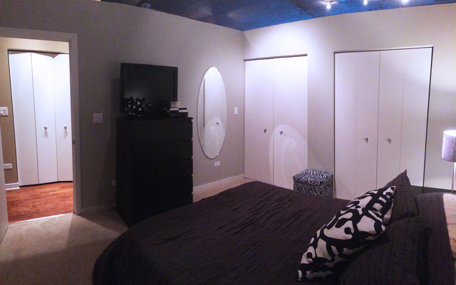 1111 West 15th Street, Unit 126 Chicago, IL 60608 - Photo 16 of 24 a bedroom with a bed and a mirror