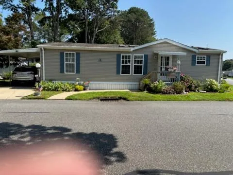 a front view of a house with a yard and potted plants
