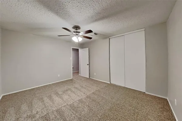 a view of an empty room with a chandelier fan