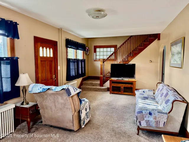 a living room with furniture a bookshelf and a window