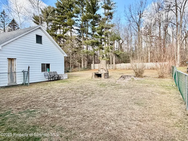 a view of a house with a yard covered in snow