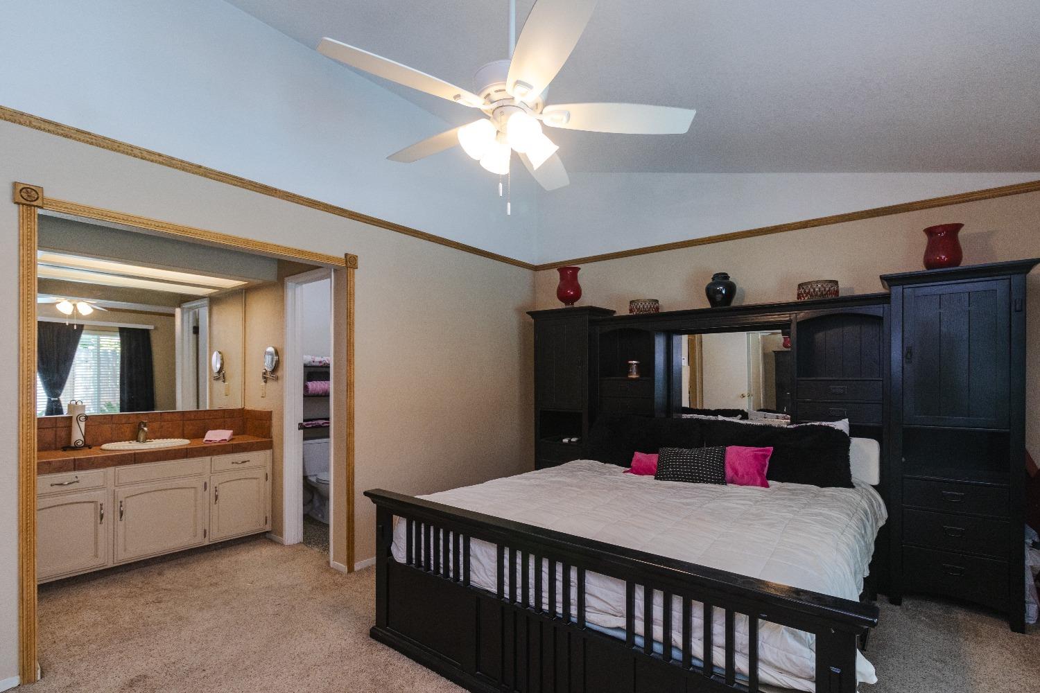 1955 Alamos Avenue Clovis, CA 93611 - Photo 14 of 28 a bedroom with a bed a mirror and dresser