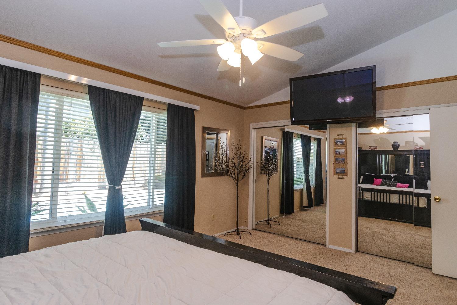 1955 Alamos Avenue Clovis, CA 93611 - Photo 15 of 28 a bedroom with a bed and a large window with a flat screen tv