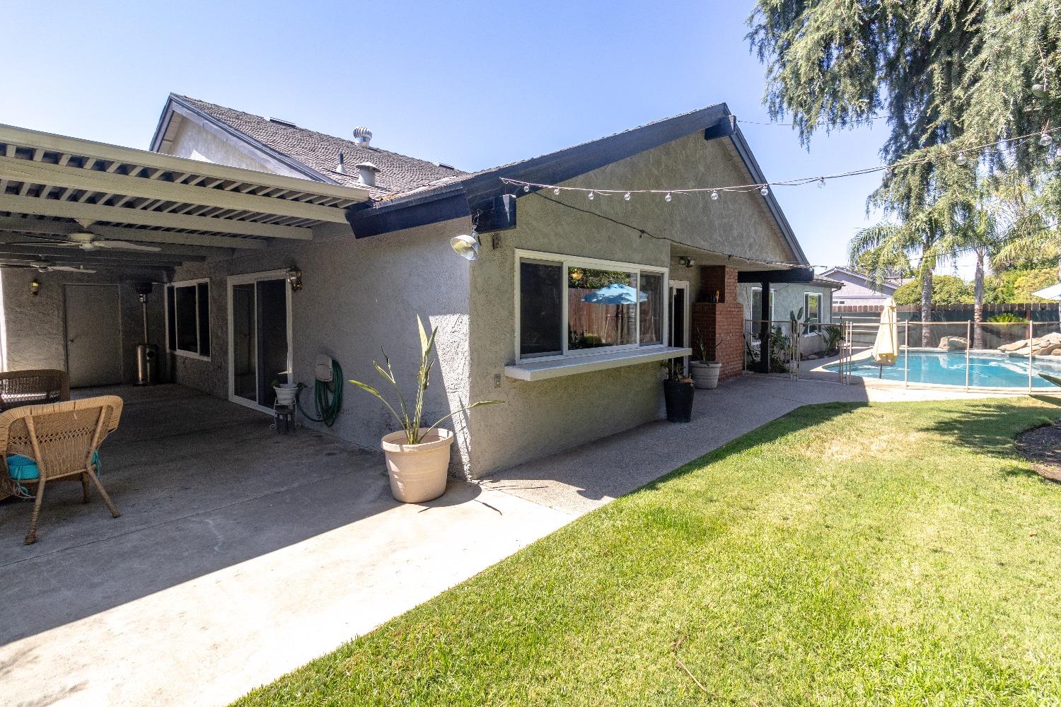 1955 Alamos Avenue Clovis, CA 93611 - Photo 23 of 28 a view of a patio with table and chairs potted plants and a large tree