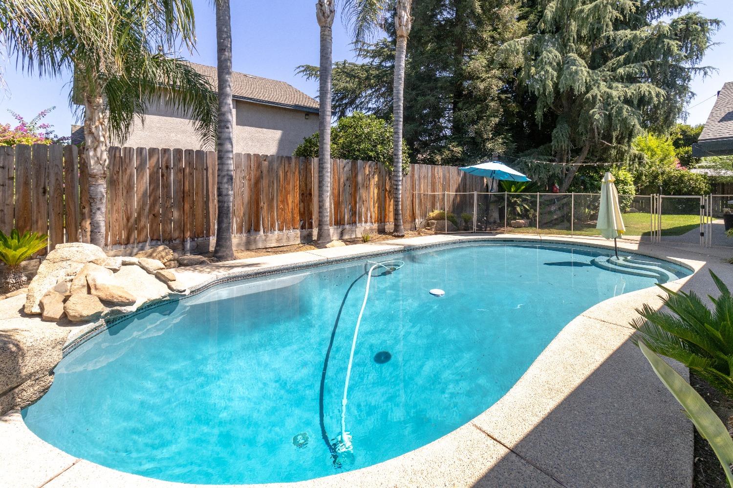 1955 Alamos Avenue Clovis, CA 93611 - Photo 26 of 28 a view of swimming pool with a backyard and trees