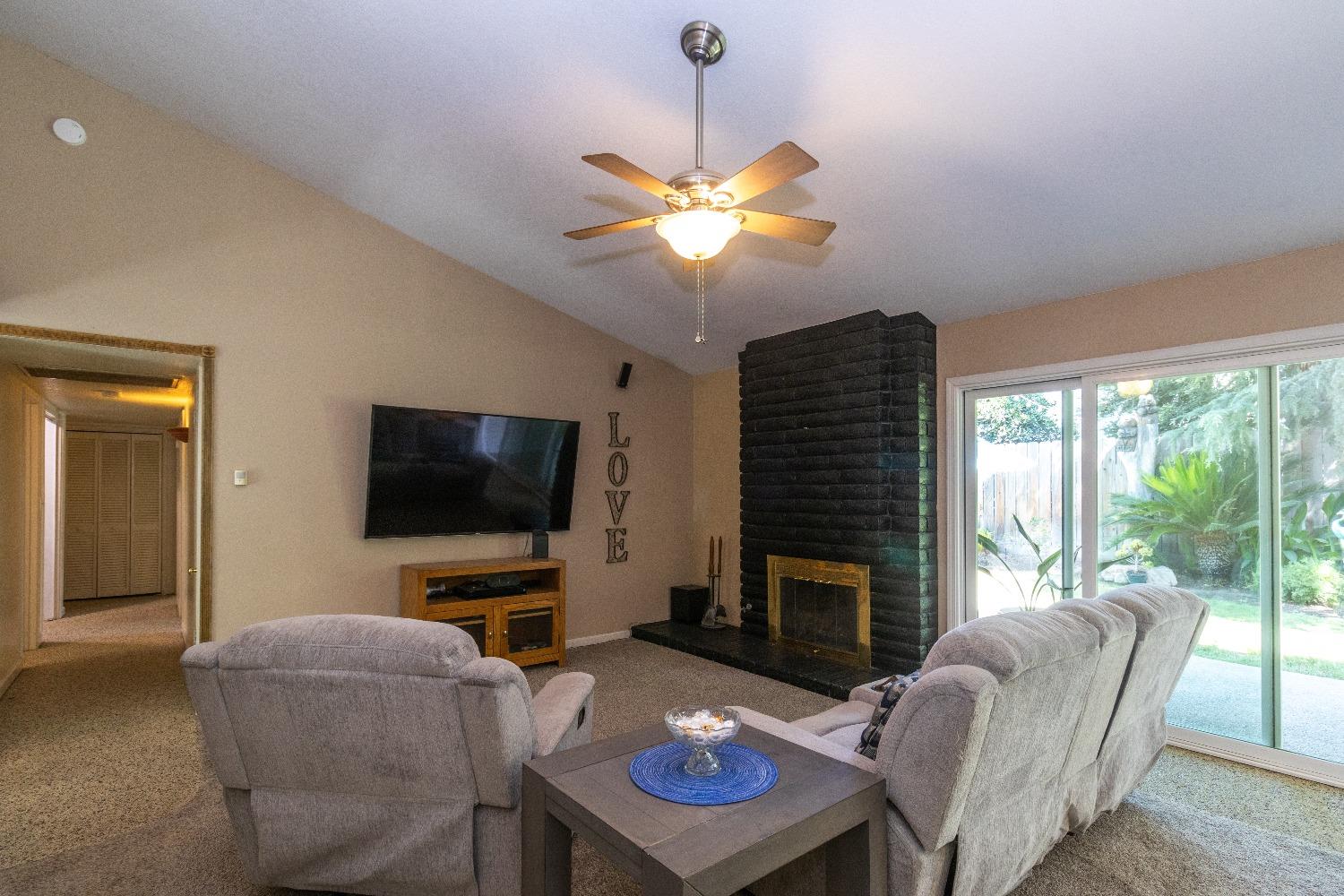 1955 Alamos Avenue Clovis, CA 93611 - Photo 6 of 28 a living room with furniture a fireplace and a flat screen tv