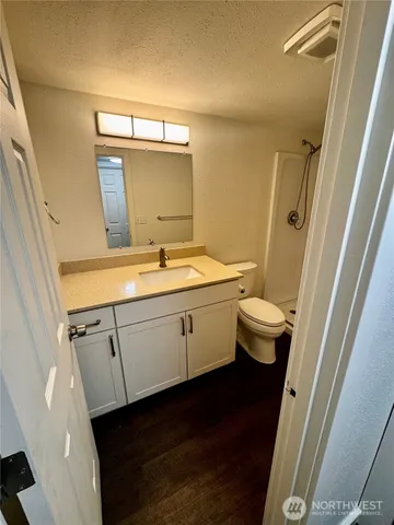 a bathroom with a granite countertop sink toilet and shower