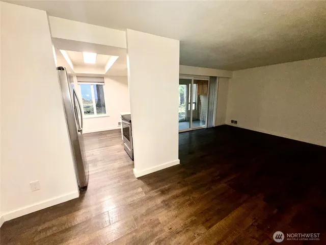 an empty room with wooden floor and a fireplace