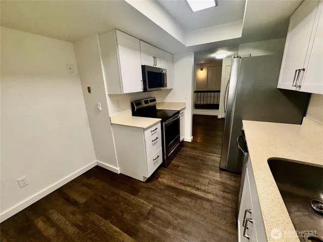 a kitchen with stainless steel appliances a stove microwave and a refrigerator