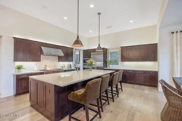 a dining room filled chandelier and wooden furniture