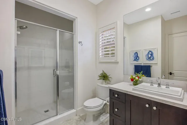 a bathroom with a granite countertop toilet sink and mirror