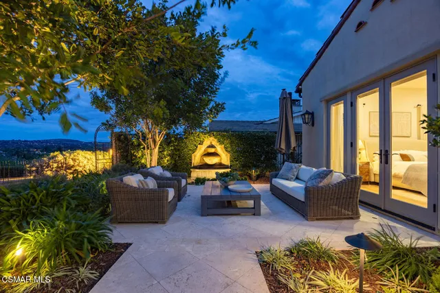 a front view of a house with garden and trees