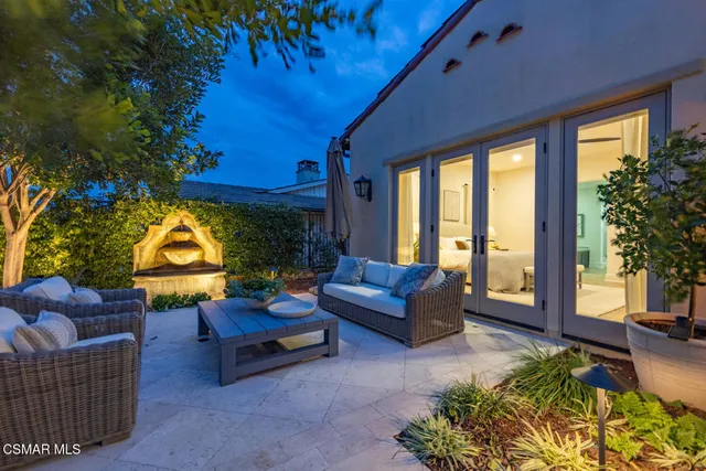 a view of a patio with couches table and chairs and potted plants