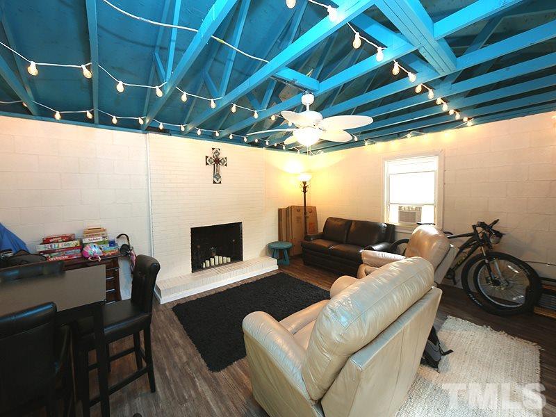 7401 Denlee Road Raleigh, NC 27603 - Photo 14 of 25 a living room with furniture a fireplace and a table