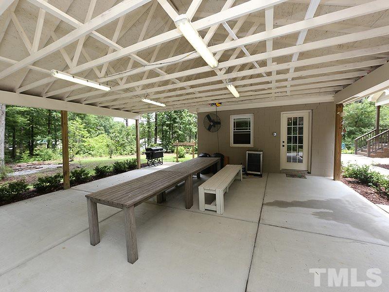 7401 Denlee Road Raleigh, NC 27603 - Photo 16 of 25 a view of a patio with a table and chairs and wooden fence