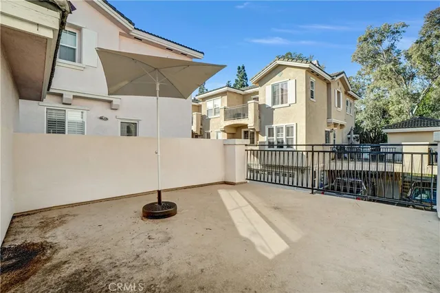 a view of a patio with a table and chairs under an umbrella