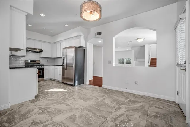 a view of kitchen with wooden cabinets and refrigerator