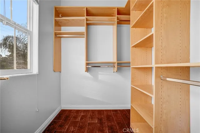 an empty room with wooden floor & bathroom