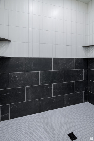3322 250 S Street Vernal, UT 84078 - Photo 18 of 37 Shower enclosure featuring white vertical subway tile, dark rectangular wall tiles with subtle veining, and a light-toned hexagonal mosaic floor