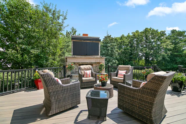 a view of a patio with couches chairs potted plants and wooden floor