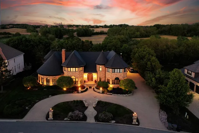 a front view of a house with yard and green space