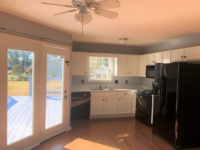 a kitchen with a sink stainless steel appliances cabinets and a large window
