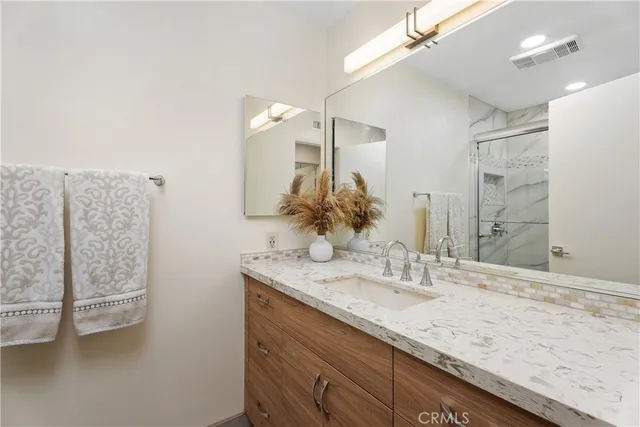 a bathroom with a granite countertop sink and a mirror