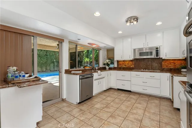 a kitchen with stainless steel appliances granite countertop a refrigerator sink and microwave