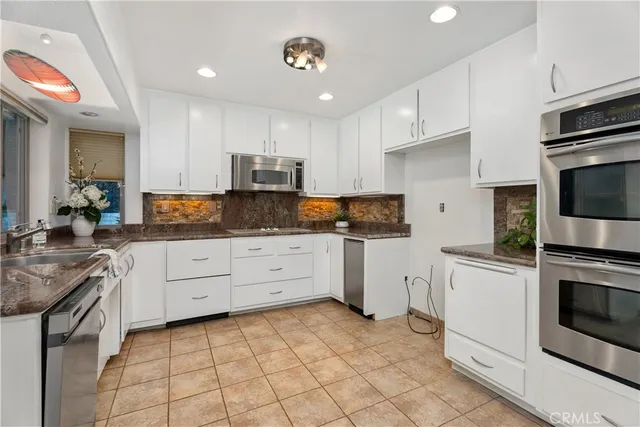 a kitchen with granite countertop cabinets and steel stainless steel appliances